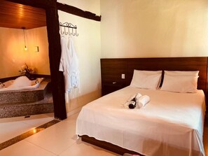 Una habitación de hotel con cama, baño con bañera y techo de madera.