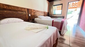 Ein Hotelzimmer mit zwei Betten, einem hölzernen Kopfteil und Blick nach draußen.