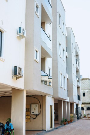 A multi-story residential building with balconies, air conditioning units, and a gated entrance. - Bubbles Apartment - Modern 2BR, Games Lounge, Sleeps 4 – Yaba, Lagos (Lagos)
