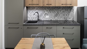 Una cocina moderna con armarios grises, un lavamanos negro y un salpicadero con diseño.