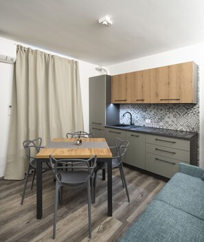 Une cuisine compacte comprenant une table à manger, des chaises et un four encastré.