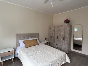 A bedroom with a bed, a nightstand, a wardrobe, and a mirror. - Apartment in Miraflores near Larcomar (Miraflores)