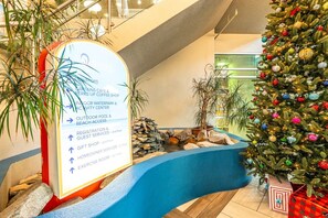 A hotel lobby with a signpost indicating amenities such as a cafe, gift shop, indoor waterpark, and exercise room. - Amazing Ocean View Condo with Waterpark and Pool (Myrtle Beach)