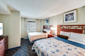 A hotel room with two beds, a television, a dresser, and a window with curtains. - Amazing Ocean View Condo with Waterpark and Pool (Myrtle Beach)