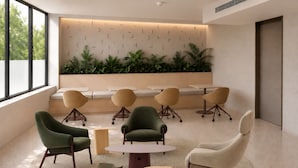 A modern lounge area with round tables and chairs, a low wall with greenery, and a large window providing natural light. - Outsite Paris - Bastille - Work, Connect, Explore. (Paris)