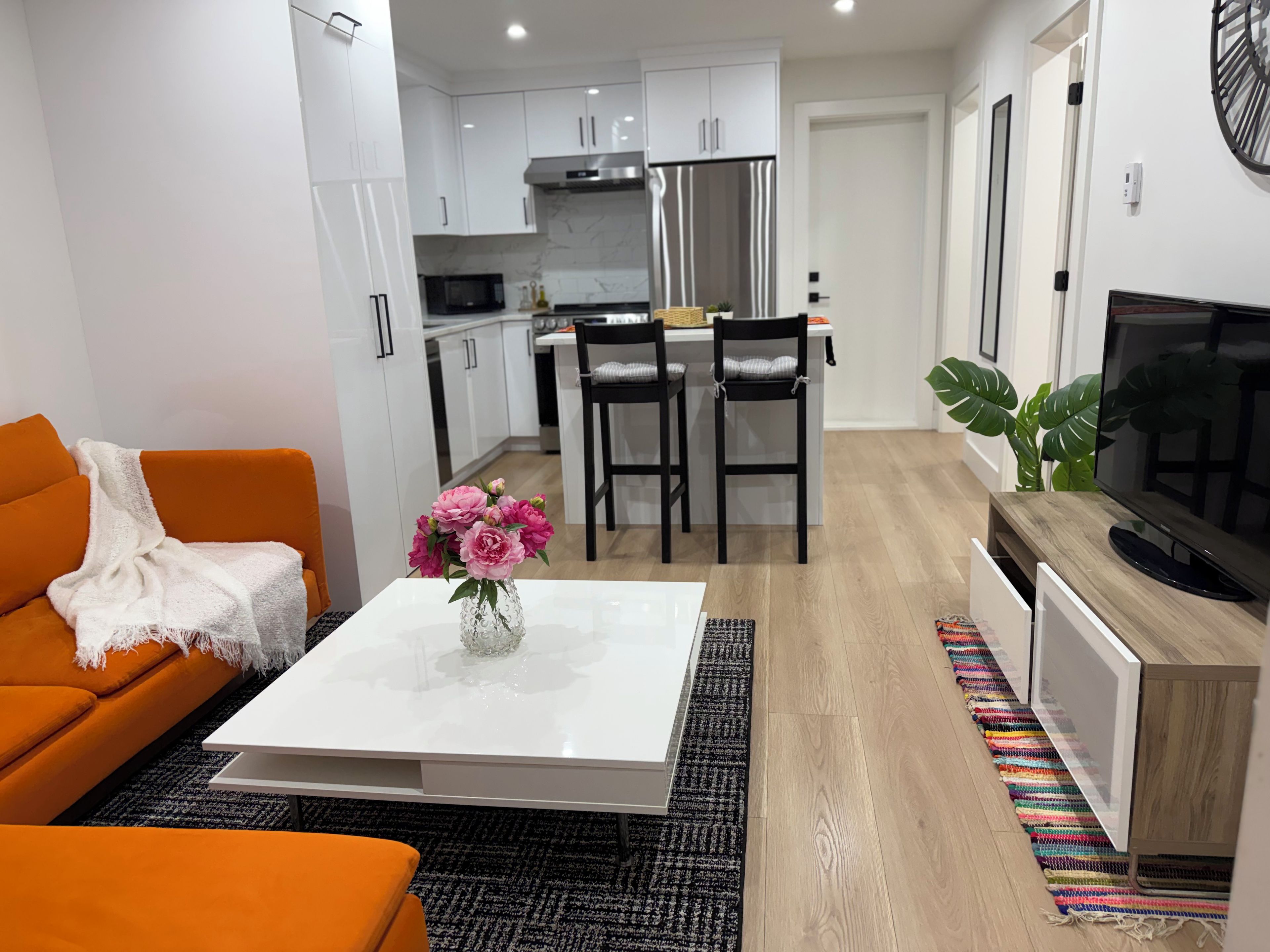 A modern living room with a sofa, coffee table, and a TV stand.