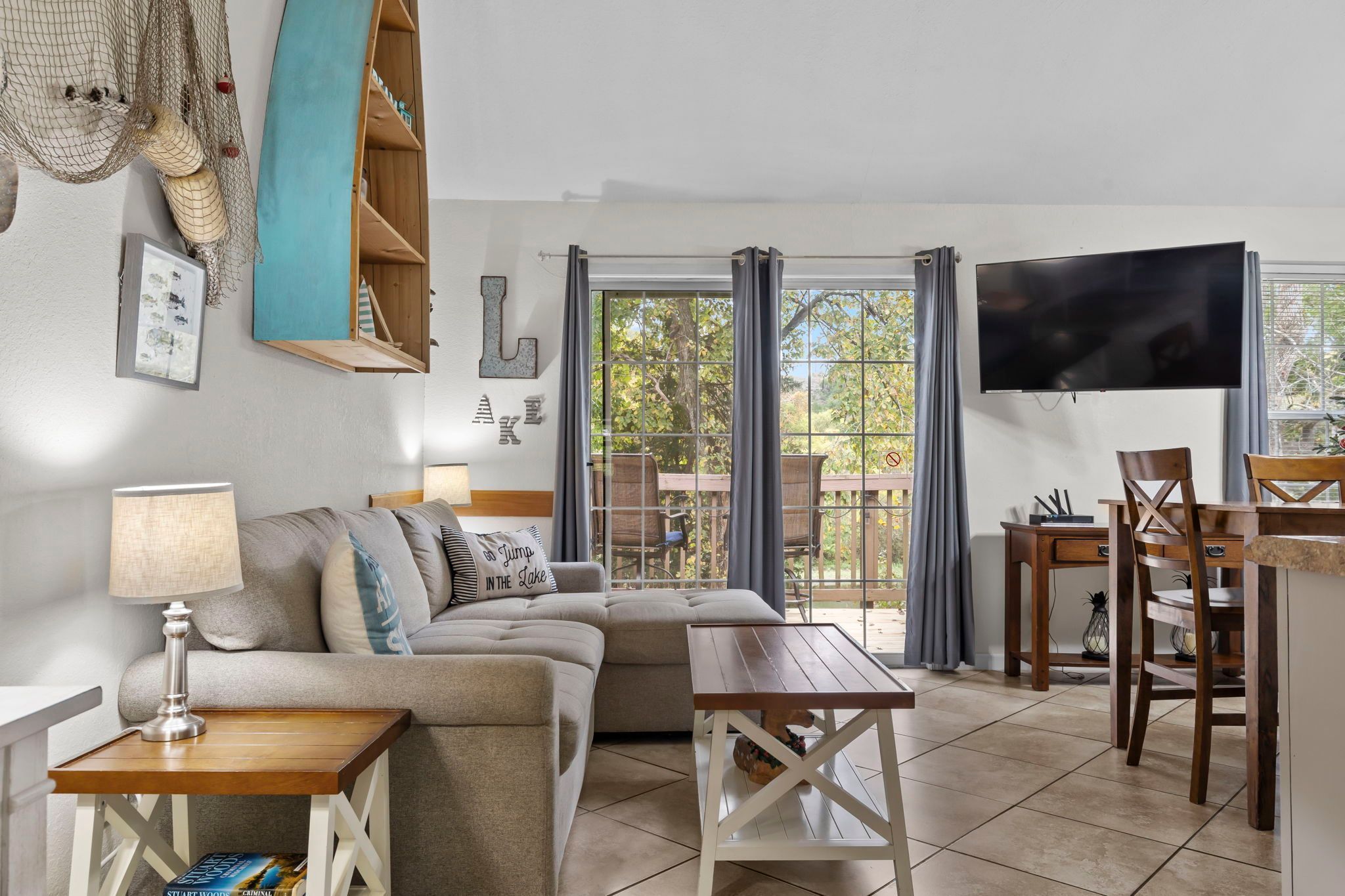 A cozy living room with a sofa, a coffee table, a TV, and a dining area with chairs and a table.