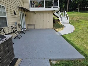 A covered patio area with a concrete floor, a small set of stairs leading up to a deck, and a metal grill unit. - 2-bedroom full Luxury Apt-Basement  in marvelous Fort Washington. (Fort Washington)
