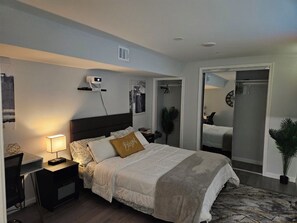 A bedroom with a bed, bedside table, lamp, and a mirror. - 2-bedroom full Luxury Apt-Basement  in marvelous Fort Washington. (Fort Washington)