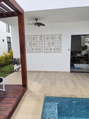 A covered outdoor area with a pool, wooden deck, and a ceiling fan. - PC Casa Palma- 3BDR in tranquil spot w/ Pool, Pergola, A/C, Parking & Security. (Estados Unidos)