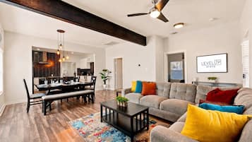 Un salon moderne avec un canapé, une table à manger et un ventilateur de plafond.