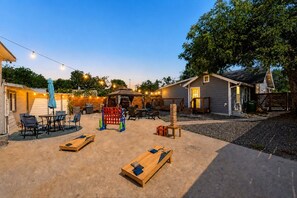 Patio con mobiliario exterior, un parque infantil de madera y una zona de estar cubierta.