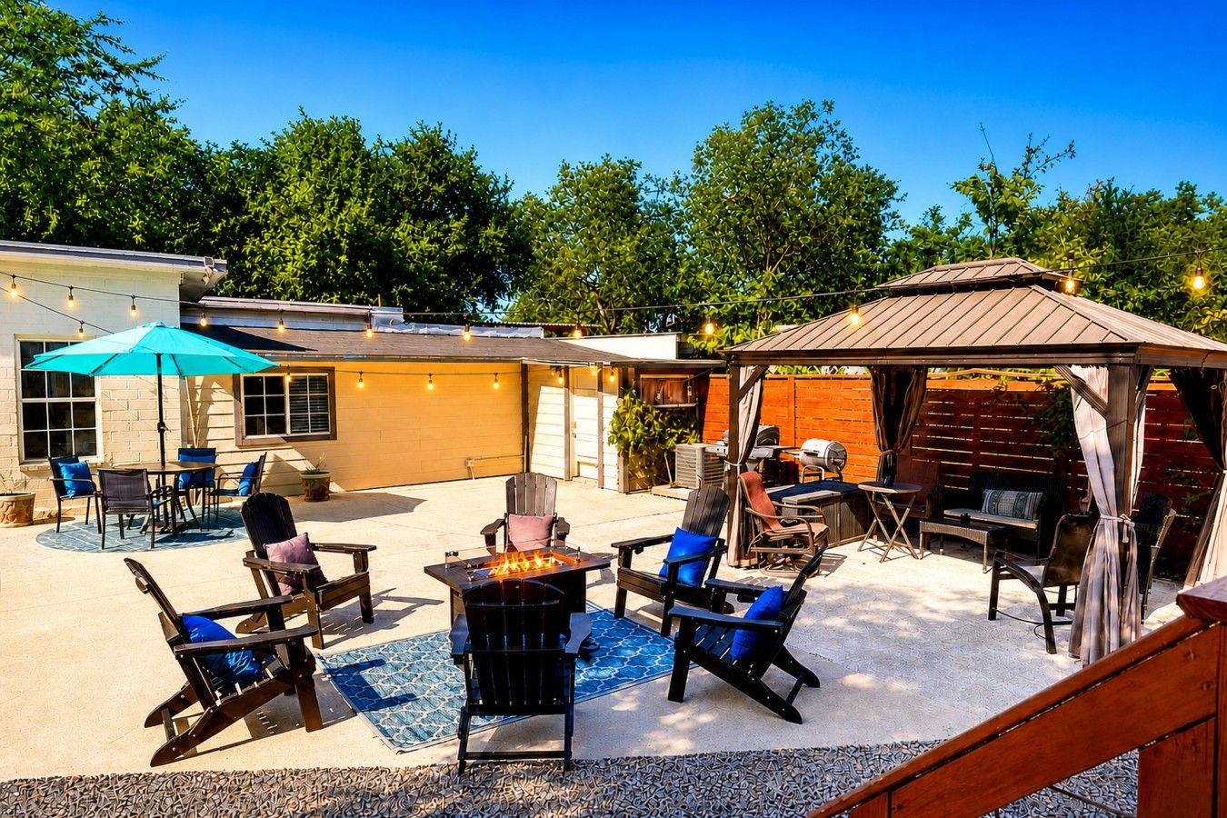 Un patio exterior con un brasero, asientos y una zona de barbacoa cubierta.