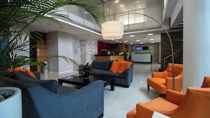 A modern lobby with seating areas, a reception desk, and a staircase. - GoUppers® Lujo en Pampatar Margarita Real (Pampatar)