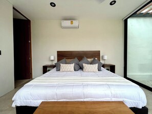 A bedroom with a large bed, bedside lamps, a wooden headboard, and a window. - Álamo House in Downtown Mérida, Pool, 2 BR (Merida)