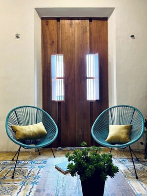 A room with a wooden door, two blue chairs with cushions, a potted plant, and a patterned floor. - Álamo House in Downtown Mérida, Pool, 2 BR (Merida)