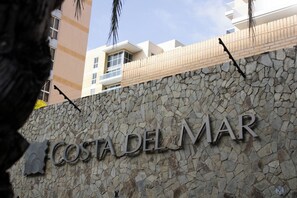 Eine Steinwand mit dem Schriftzug 'COSTA DEL MAR', der den Namen eines Hotels oder Resorts angibt.