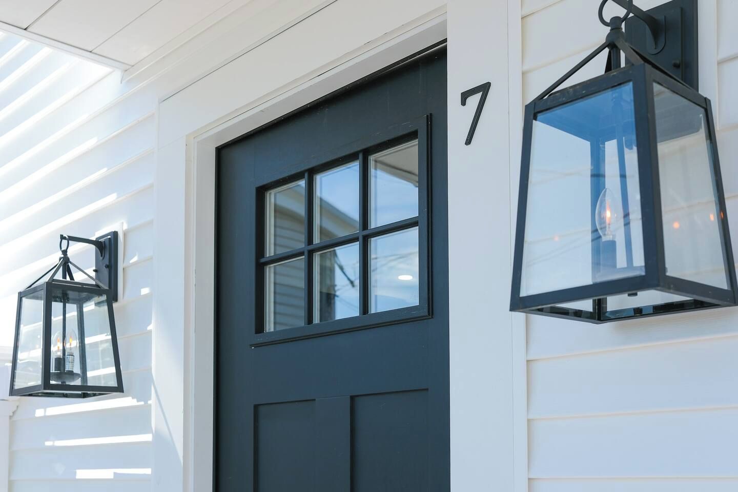 A dark-colored door with a number '7' on the wall beside it.