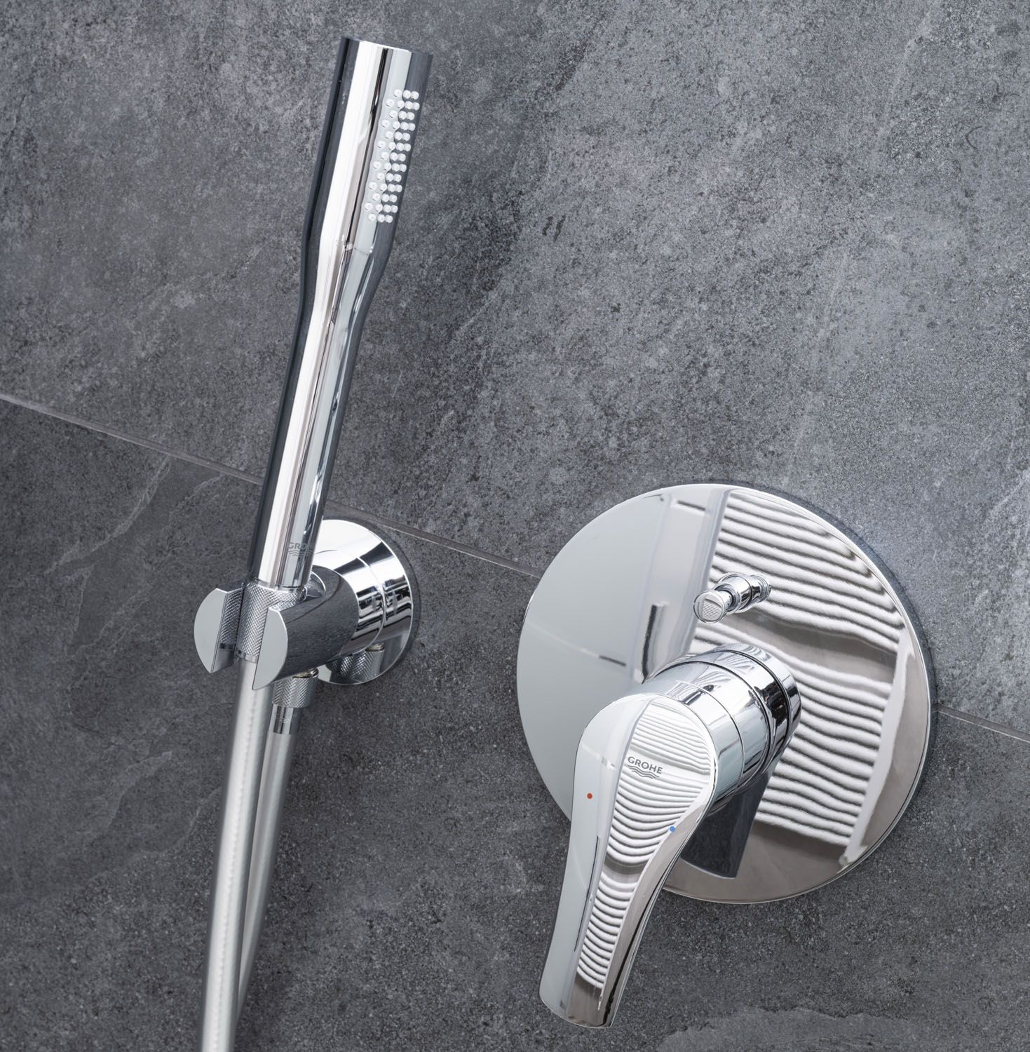 A modern bathroom with a chrome shower head, a handheld shower, and a wall-mounted faucet.