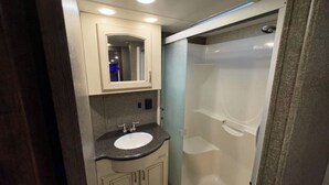 Une petite salle de bain comprenant un lavabo, un miroir et une douche.