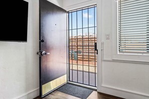 A door with a metal gate, a doormat, and a window with blinds. - Cozy Central Tucson 1BR | Near UofA & Downtown (Tucson)