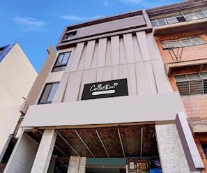 A multi-story building with a prominent sign for 'Collection Company-Serviced'. - Classic With Twin Bed Hotel Metro Park (Bengaluru)
