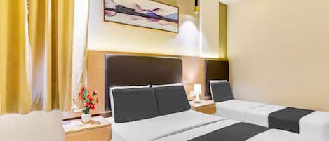 A hotel room with two beds, a nightstand with a lamp, a painting on the wall, and a window with curtains.