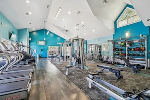 Ein Fitnessstudio mit Laufbändern, Kraftgeräten sowie verschiedenen Gewichten und Medizinbällen.
