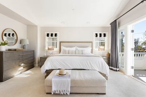 A bedroom with a large bed, bedside tables, a dresser, a mirror, and a view through a sliding door. - Mins to Beach, Perfect for Families, Fire Pit W/AC! (Newport Beach)