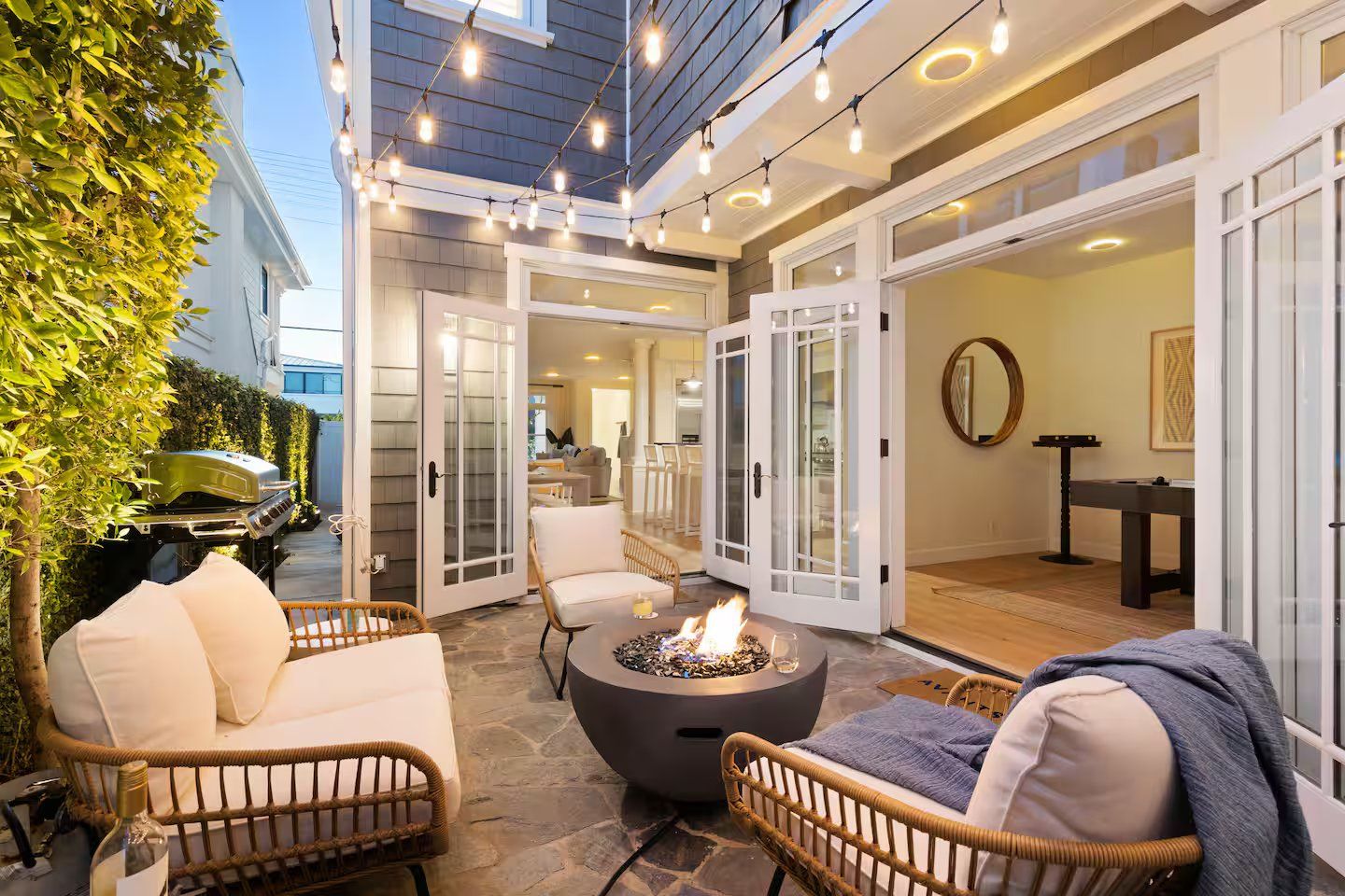 An outdoor patio with wicker furniture, a fire pit, and a grill.