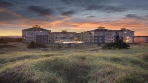 A multi-story hotel with a flat roof, balconies, and a central courtyard. - Long Beach WA Fireplace 2BR Queen Suite – WorldMark Long Beach (Long Beach)