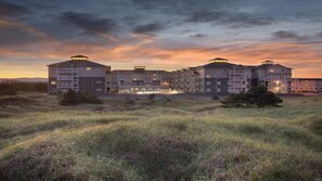 Ein mehrstöckiges Hotel mit flachem Dach, Balkonen und einem Innenhof.