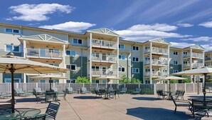 A multi-story residential building with balconies, outdoor seating, and a clear sky. - Long Beach WA Fireplace 2BR Queen Suite – WorldMark Long Beach (Long Beach)