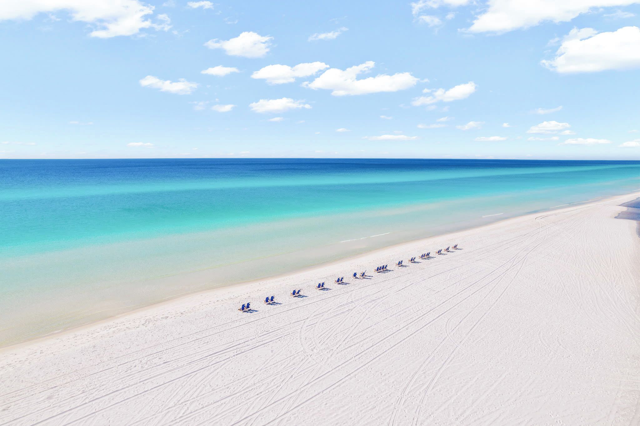 Ein Strand mit blauem Himmel und ruhigem Meer.