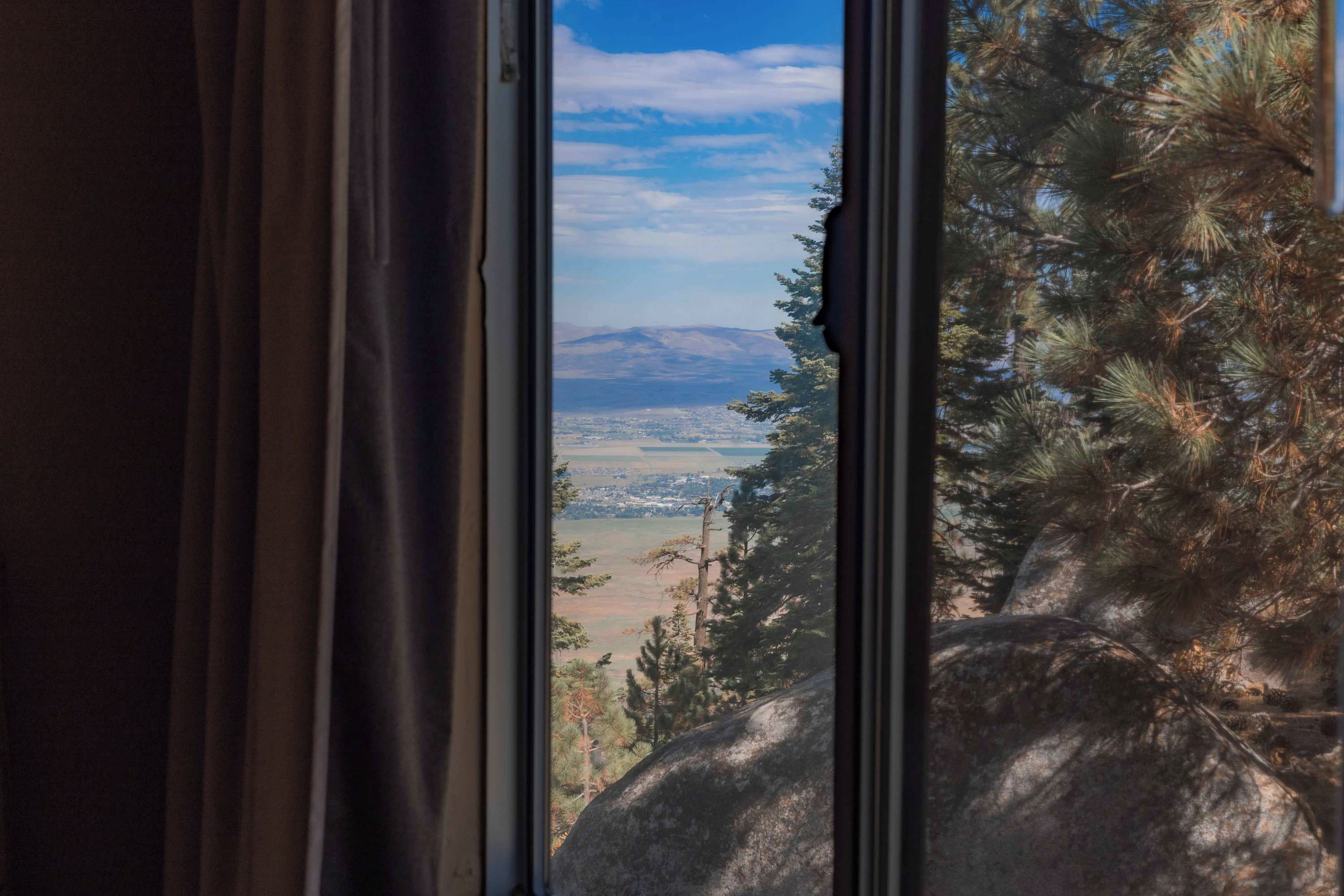 A window view of a mountainous landscape with a clear sky.