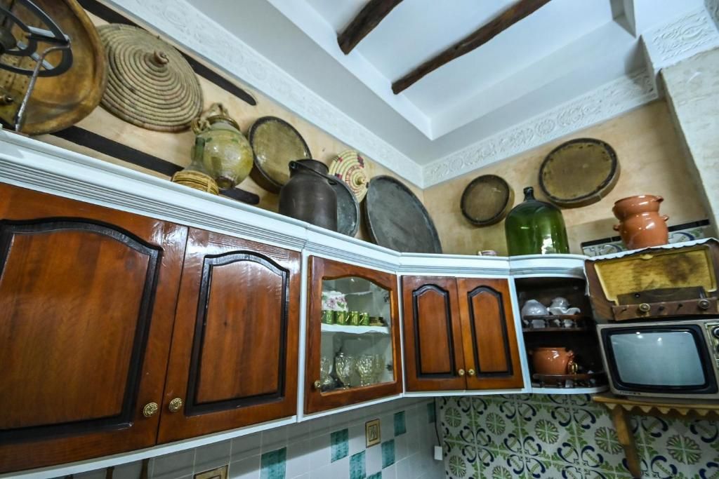 A kitchen with wooden cabinets, a microwave, and various kitchenware on the wall.