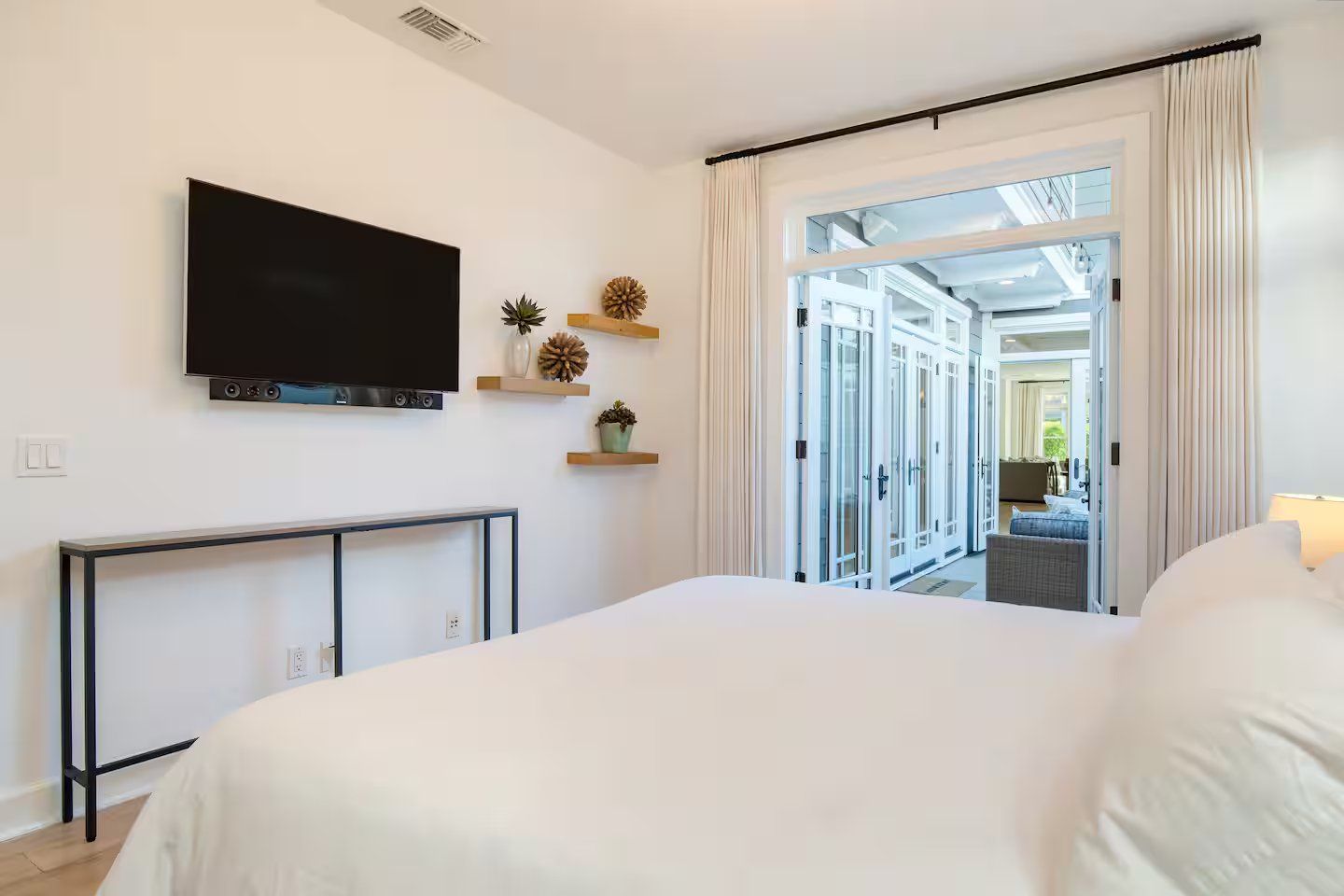 Une chambre d’hôtel équipée d’un lit, d’une télévision, d’un bureau et donnant sur le couloir de l’hôtel.