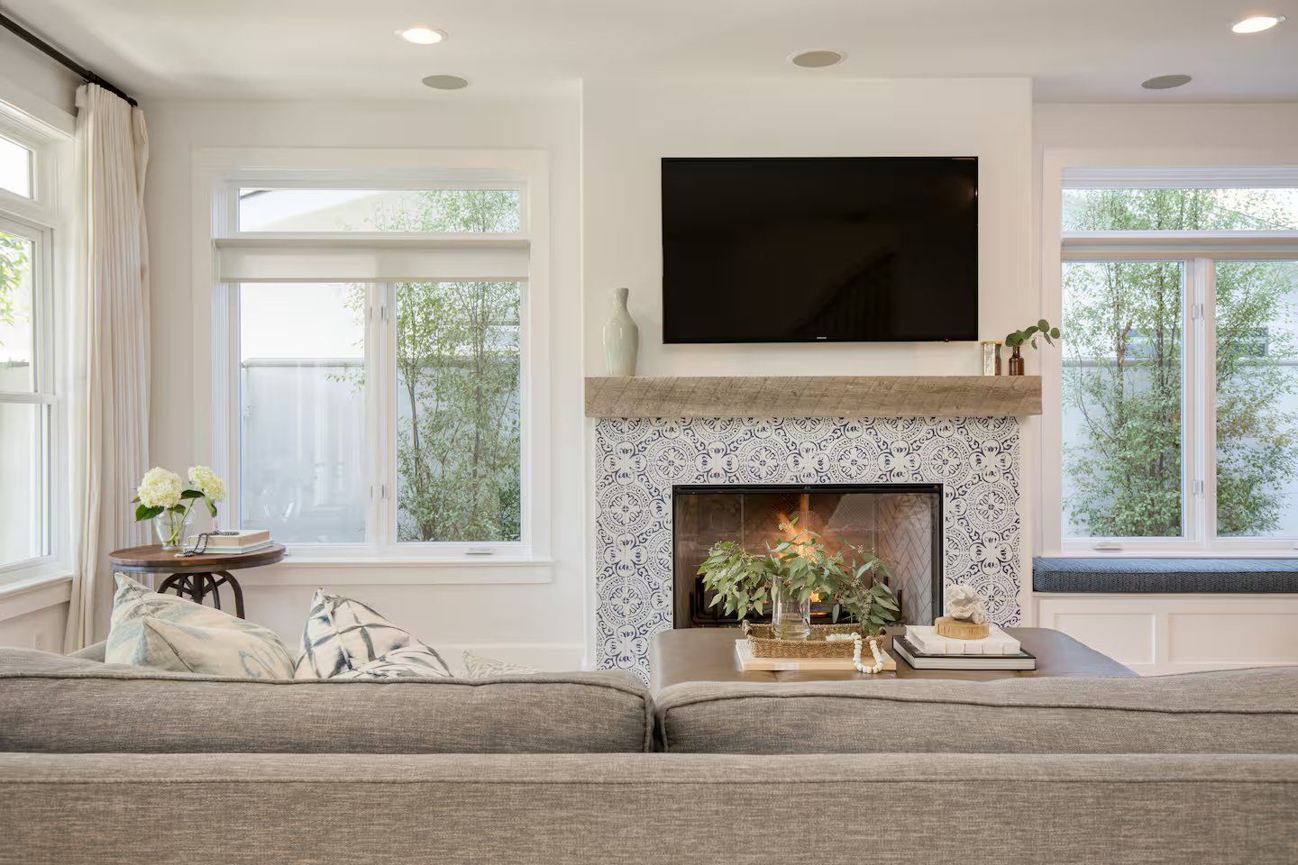 Una sala de estar con chimenea, un televisor de pantalla plana montado encima y un sofá.