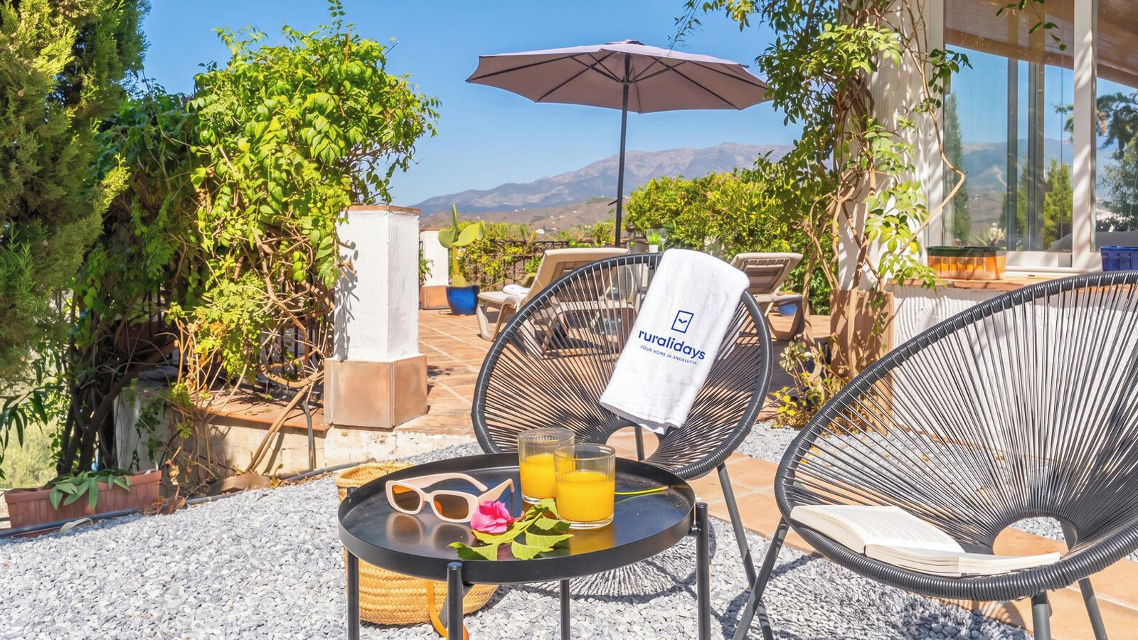 An outdoor seating area with a table, chairs, and a drink.