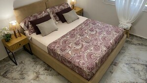 Une chambre à coucher avec un lit, des tables de chevet, une lampe et une fenêtre avec des rideaux.