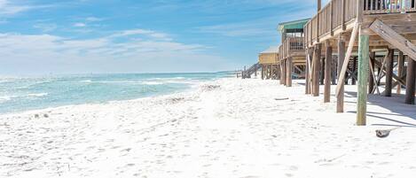 A beach with wooden structures, likely a resort, and a clear sky.