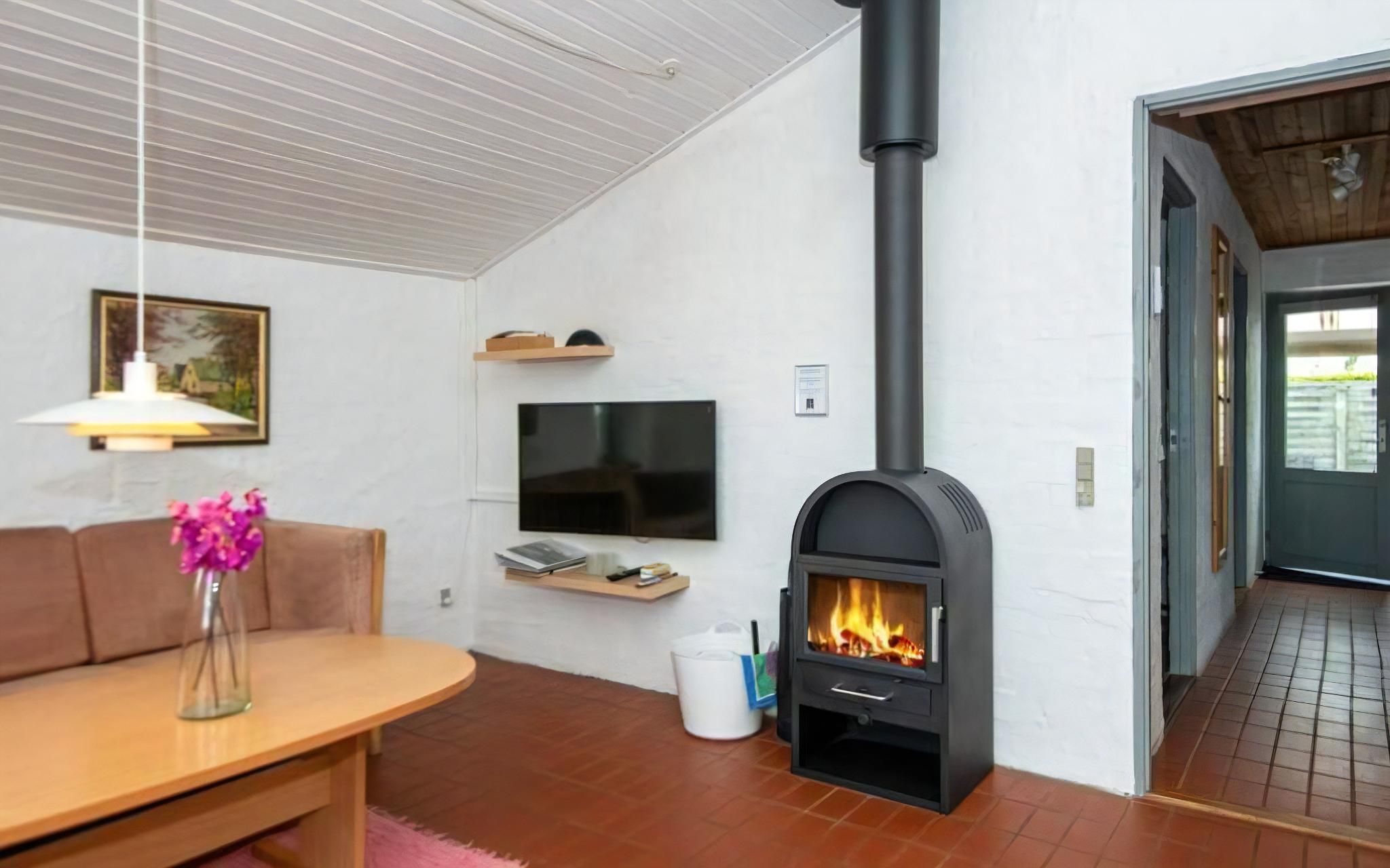 A modern living room with a fireplace, a flat-screen TV, and a dining area.