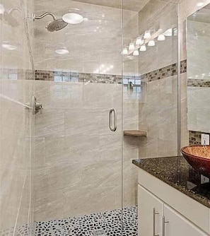 A glass-enclosed shower with a handheld showerhead, a tiled backsplash, and a countertop with a vessel sink. - Poolside Pokes...Walk to OSU!!! (Stillwater)