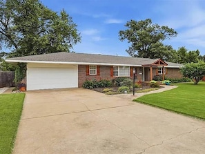 A single-story house with a garage, a front lawn, and a mailbox.