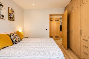 Ein Schlafzimmer mit einem Bett, einem Kleiderschrank und einer Tür zu einem anderen Raum.