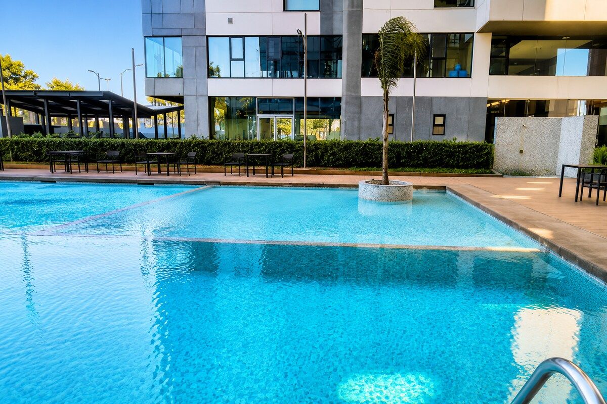 Ein Schwimmbecken mit einem modernen Gebäude im Hintergrund.