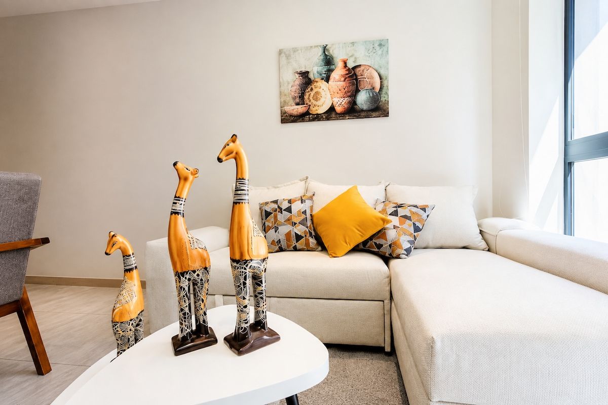 A living room with a sofa, a coffee table, and decorative giraffe figurines.