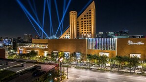 Un hotel de diseño moderno, con una torre destacada y fachada con ventanas iluminadas.