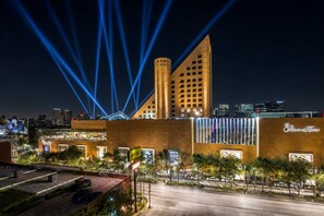 Ein Hotel mit modernem Design, das mit einem markanten Turm und einer Fassade mit beleuchteten Fenstern besticht.