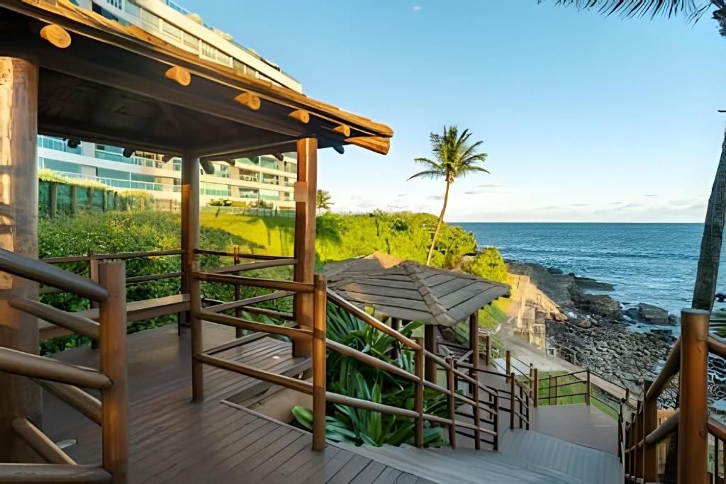 A wooden deck with a view of the ocean and a building in the background.